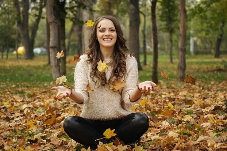 Happy woman sitting in a forest