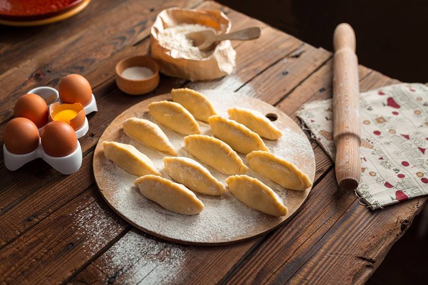 Dumplings, rolling pin, eggs and flour on a table