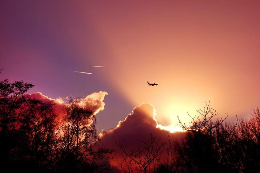 Airplane flying at sunset