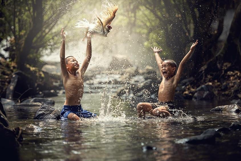 Happy kids playing in a river