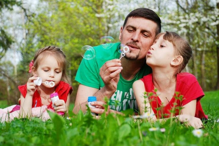 Father and daughters blowing bubbles