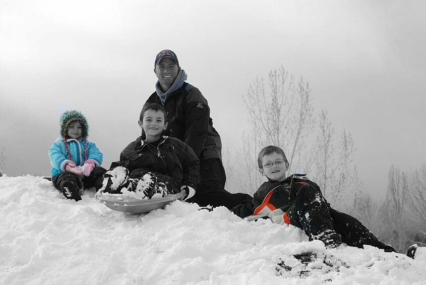 Father and 3 children enjoying the snow