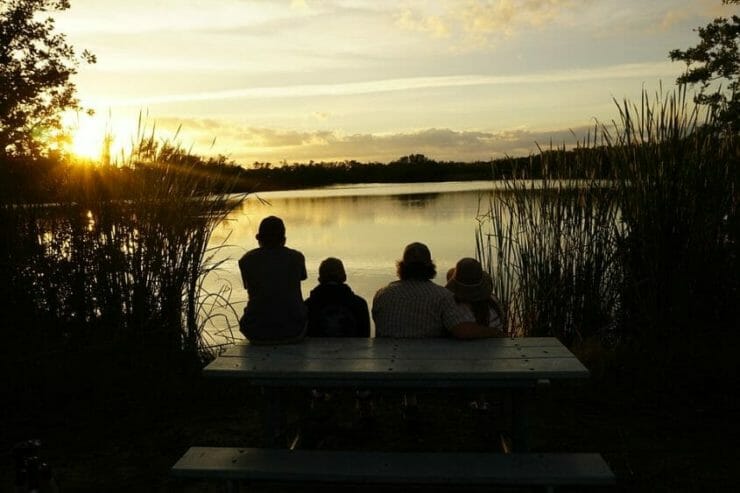 Family watching the sunset by a lake