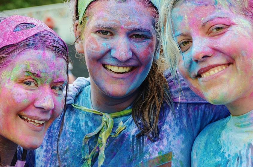 3 excited young woman in costumes covered in paint