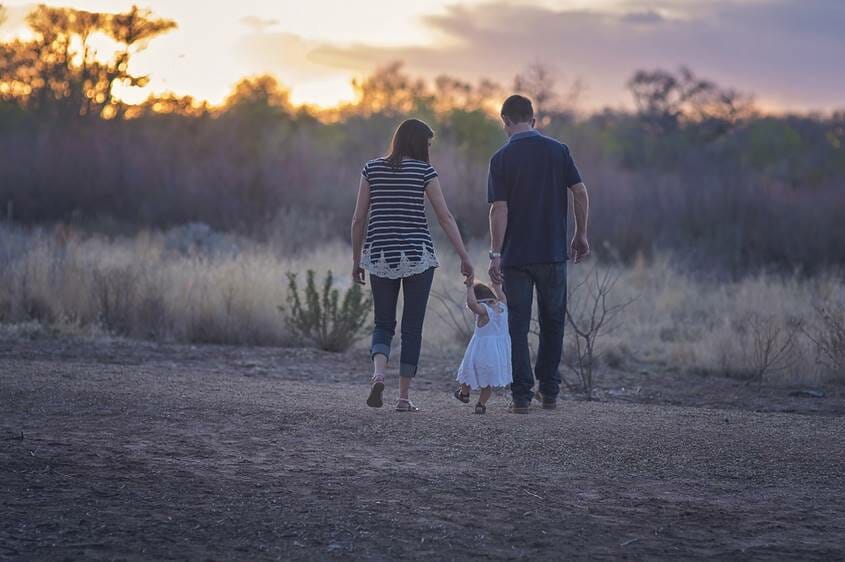 Parents walking in nature with young daughter