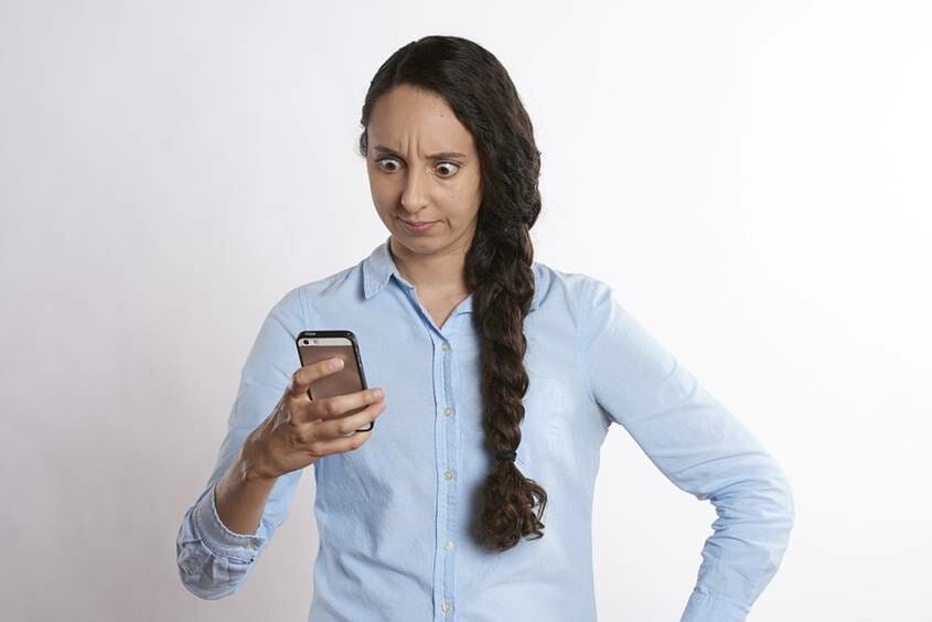 Woman looking upset with mobile phone in hand