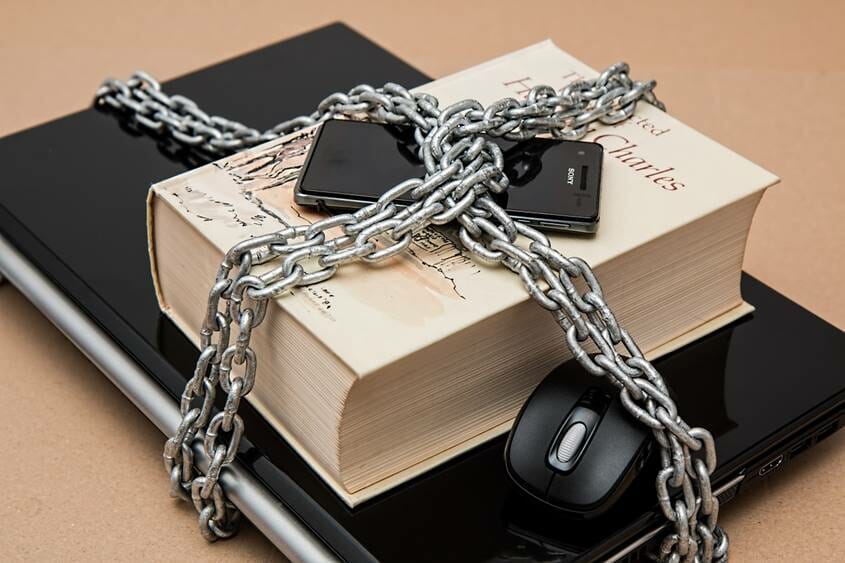 Mobile phone, book and laptop computer under lock and chain