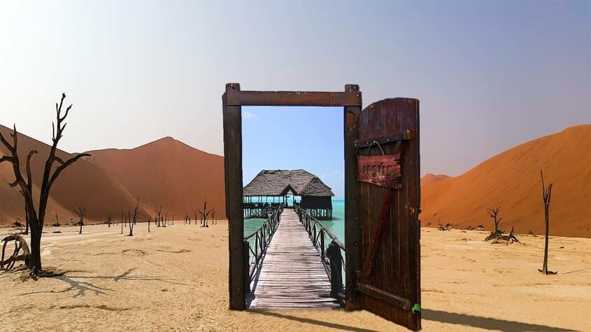 Door open in the desert leading to tropical island