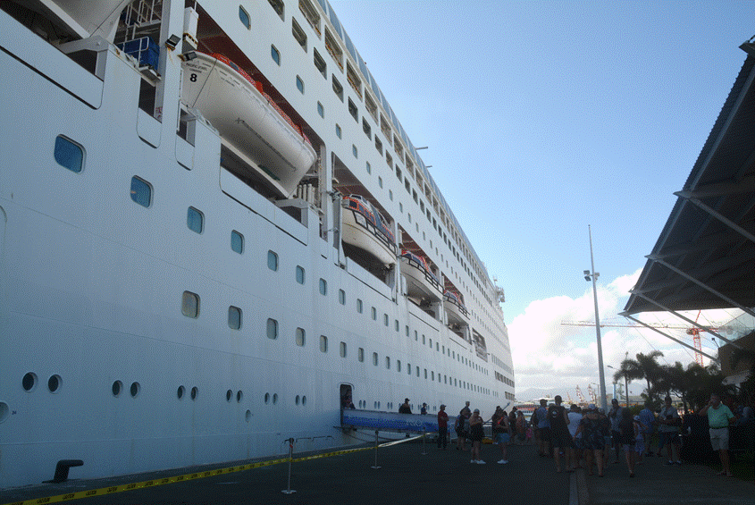 People looking small next to a cruise ship