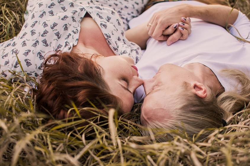 Couple in a hot relationship lying on the grass