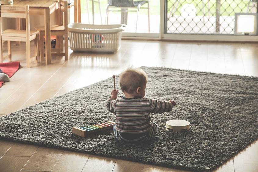 Baby on the carpet with xylophone and tamborine