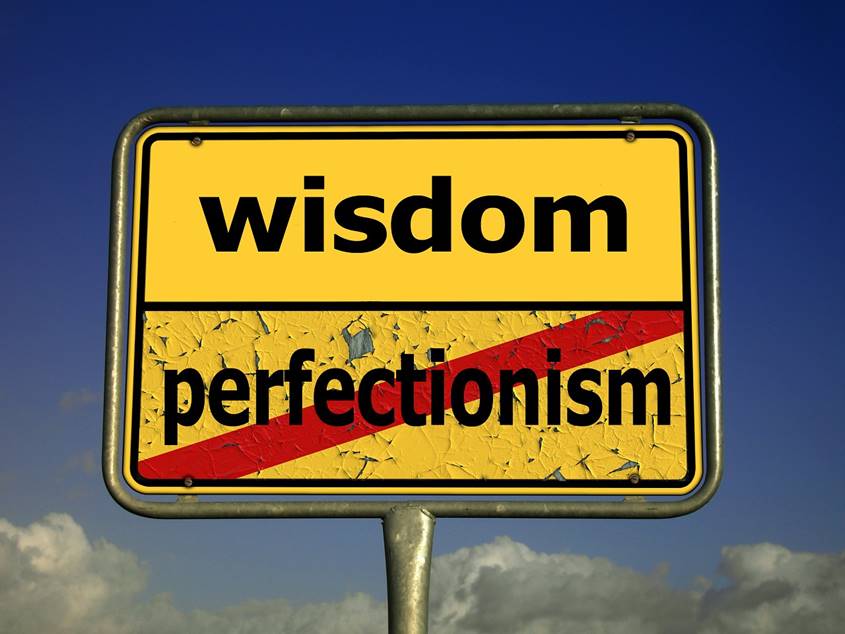 Sign showing the word Wisdom above the over-stricken word Perfectionism