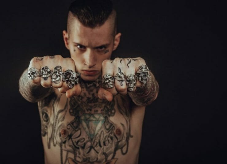 Young man with tattoos and skill rings (may or may not be abusive)