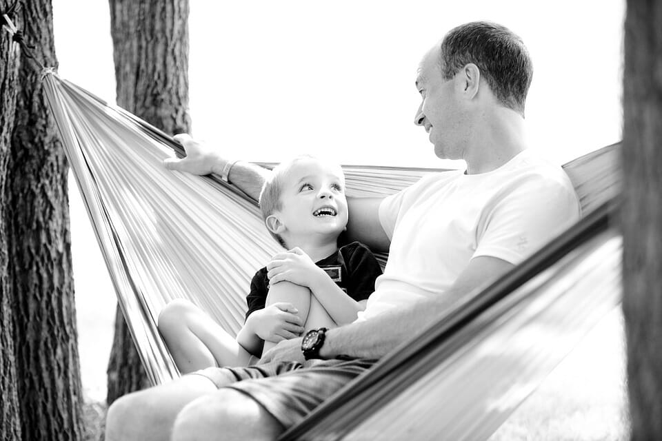 Happy boy on a hammock with his father