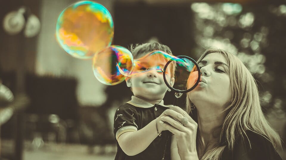 Woman and little boy blowing bubbles