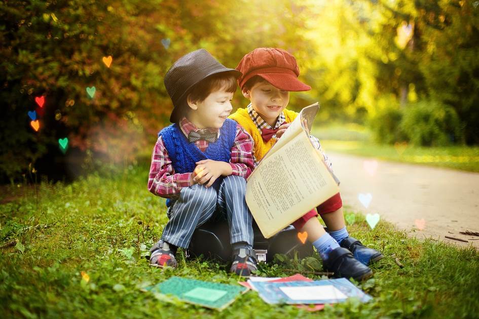 2 boys in old fashioned clothes reading a book