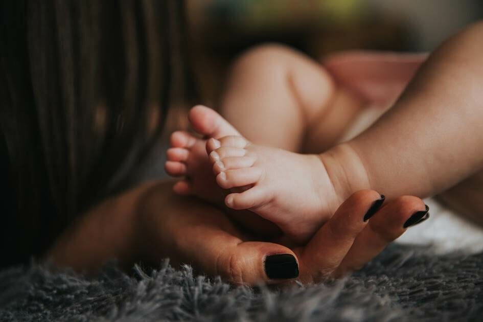 Mother's hand holding baby's feet