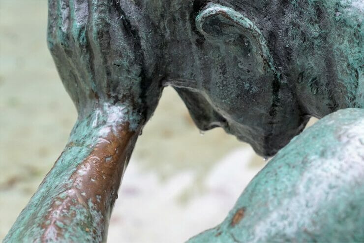 Bronze sculpture of man holding his head