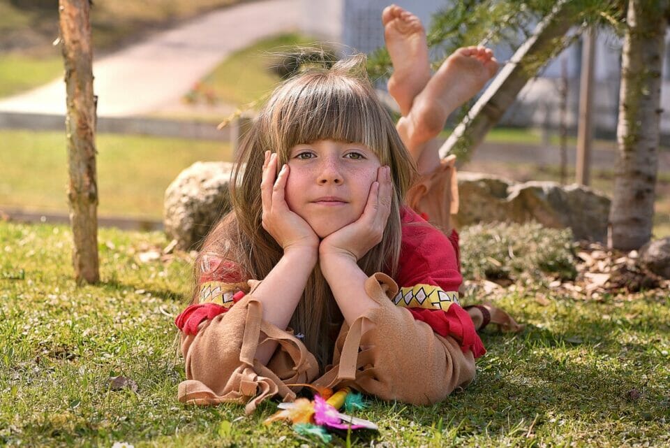 Girl lying on the grass looking bored