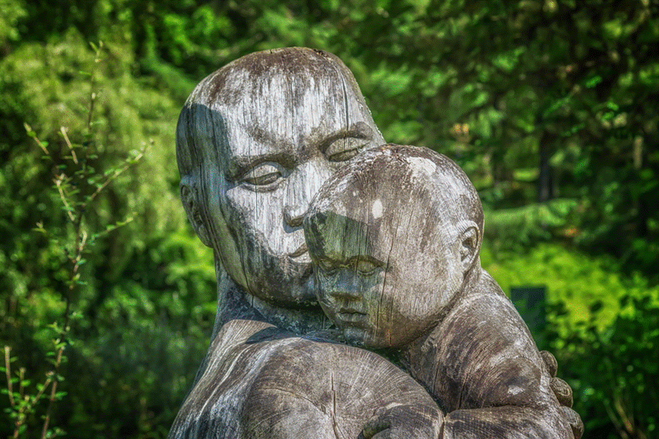 Asian sculpture of father holding baby