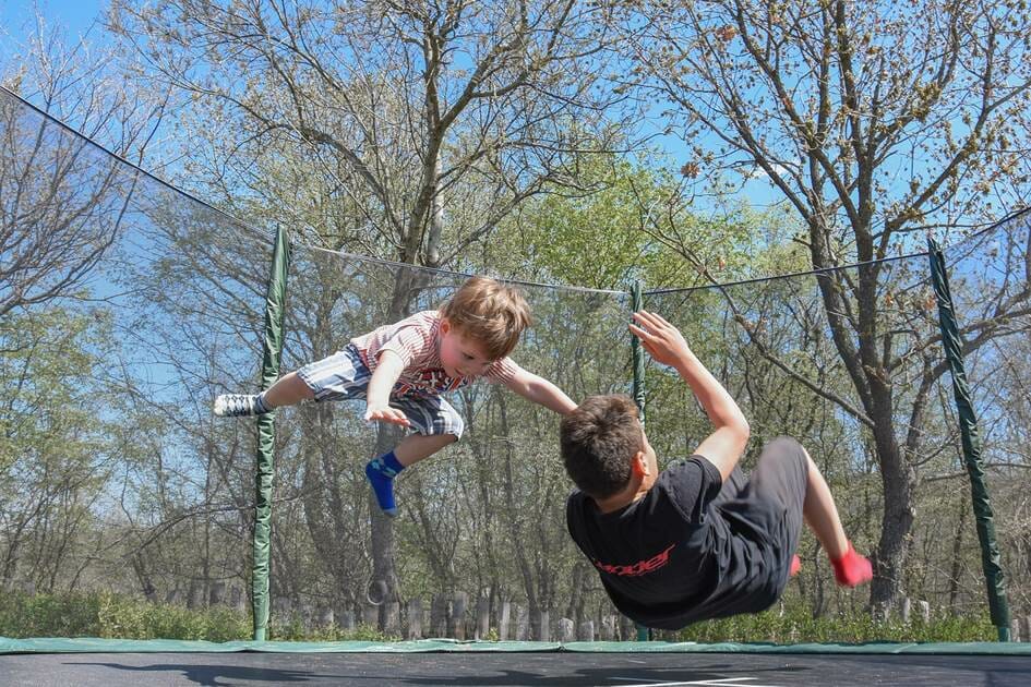 2 boys jumping on a trampoline