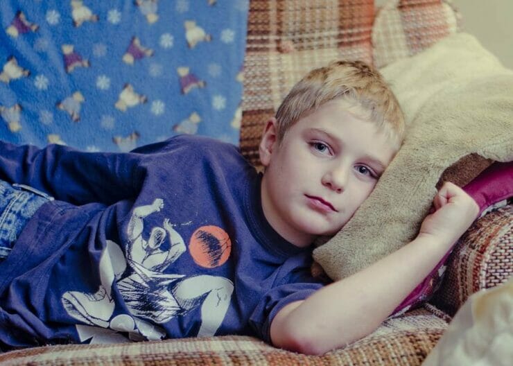 Boy lying on the couch looking bored