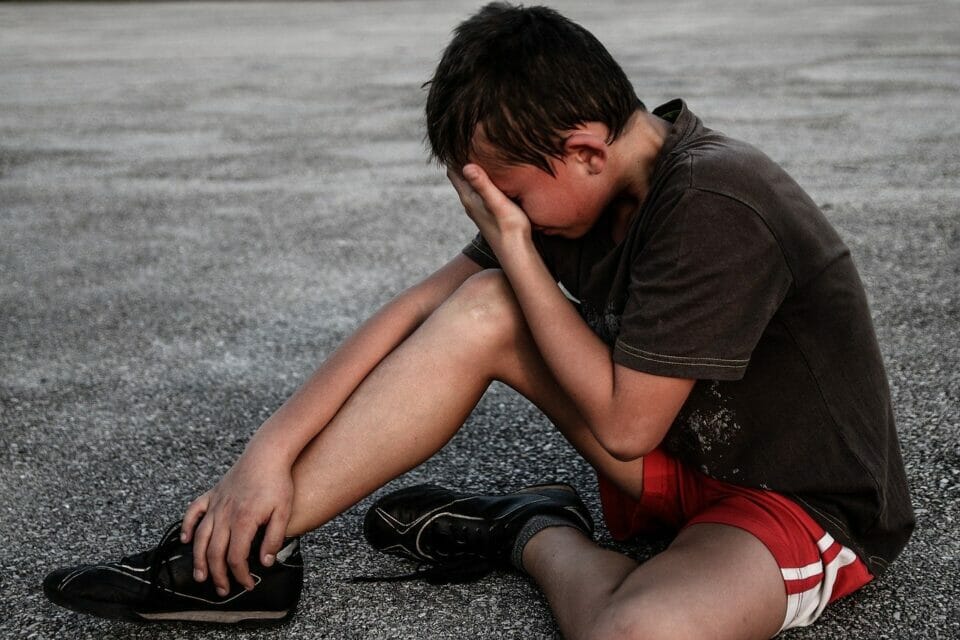 Boy sitting on the ground crying