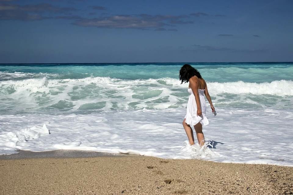 Woman wading in the ocean water on the beach