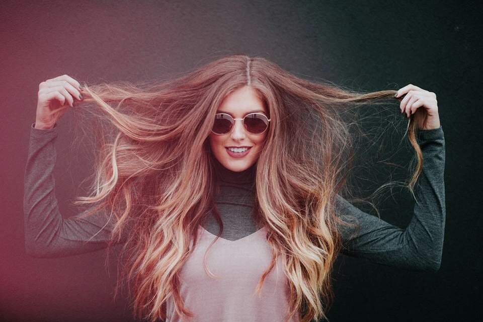 Woman holding her hair to the sides and smiling