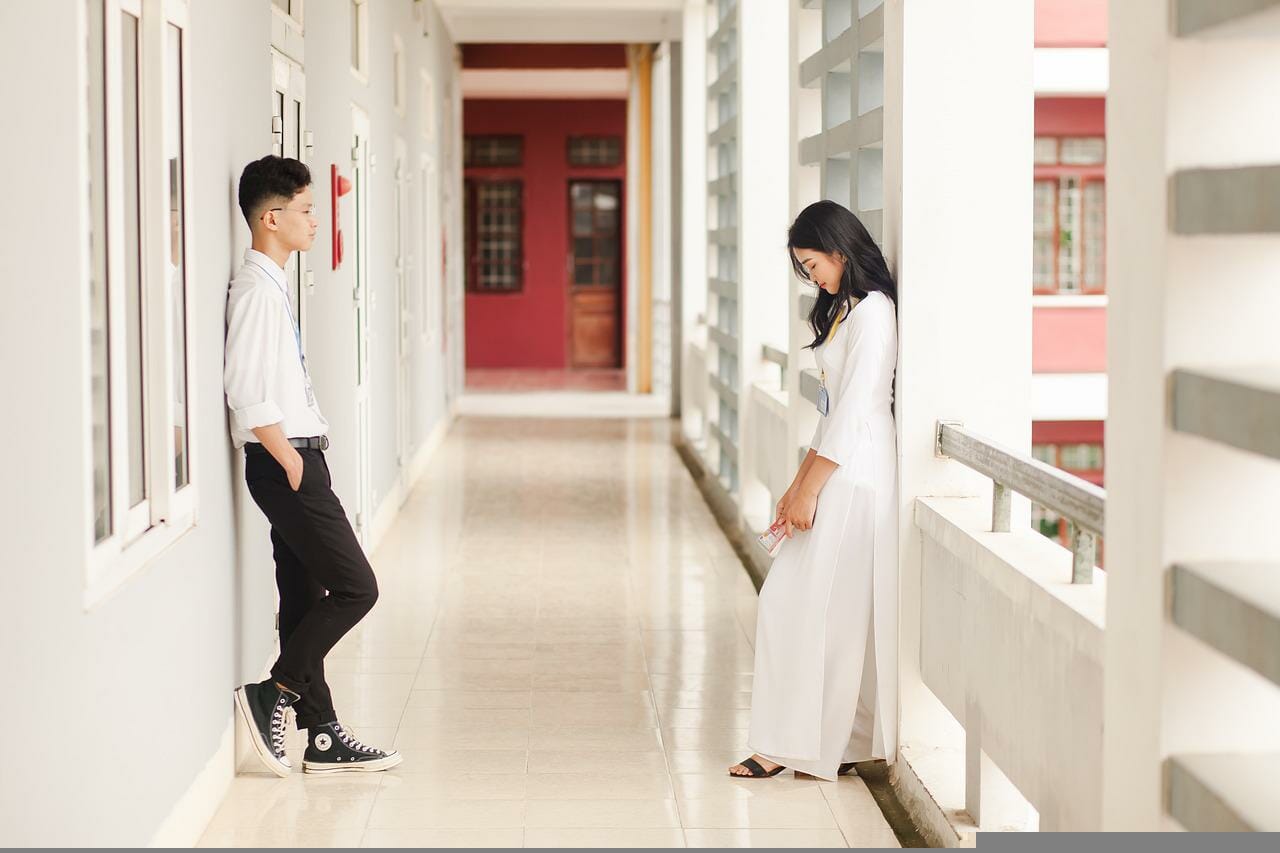 Teen couple in school corridor