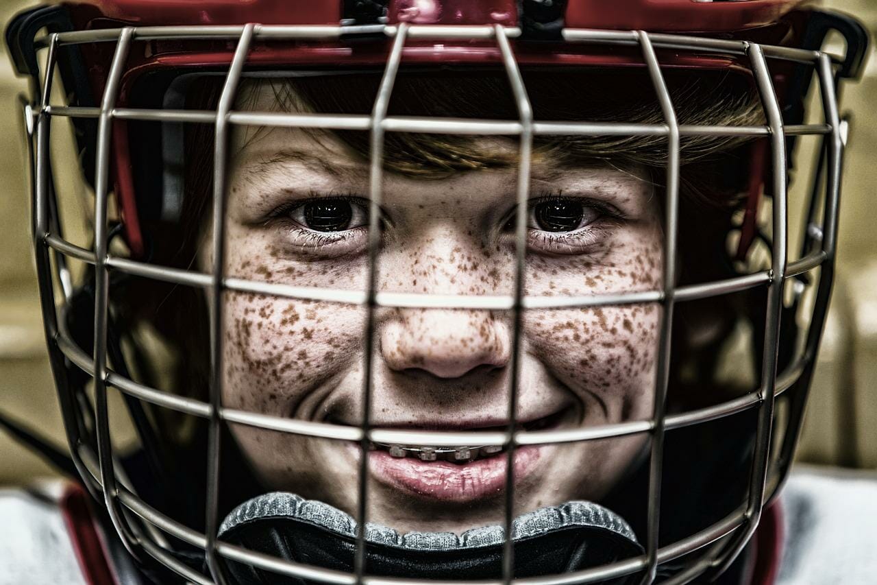 Happy boy in hockey helmet and braces
