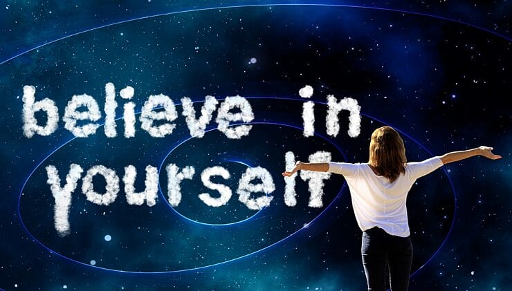 Woman looking at clouds spelling Believe in Yourself