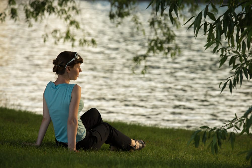 Woman sitting by a lake for a quiet moment