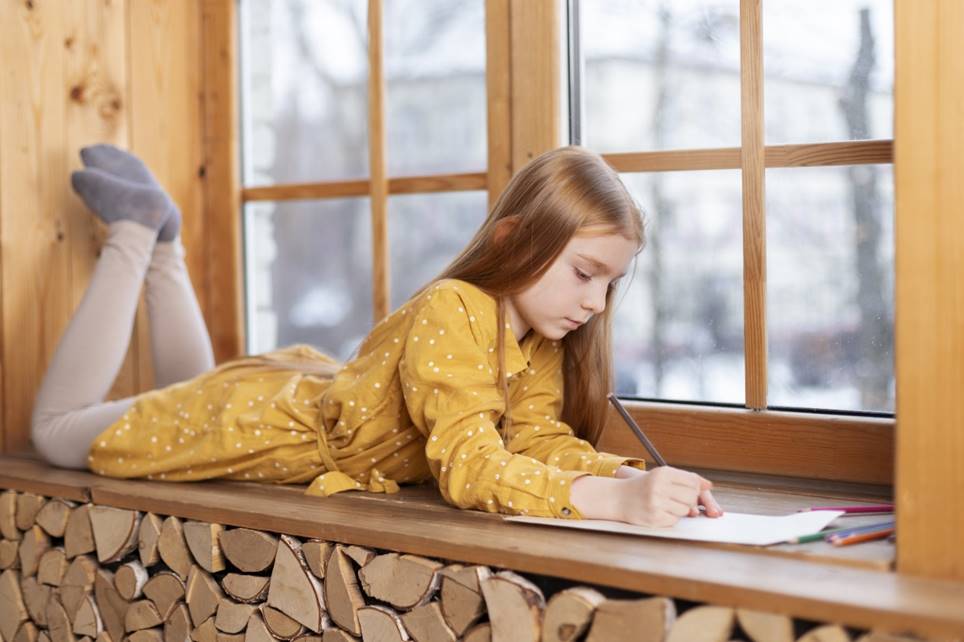 Child practicing mindfulness for kids during a quiet moment by the window