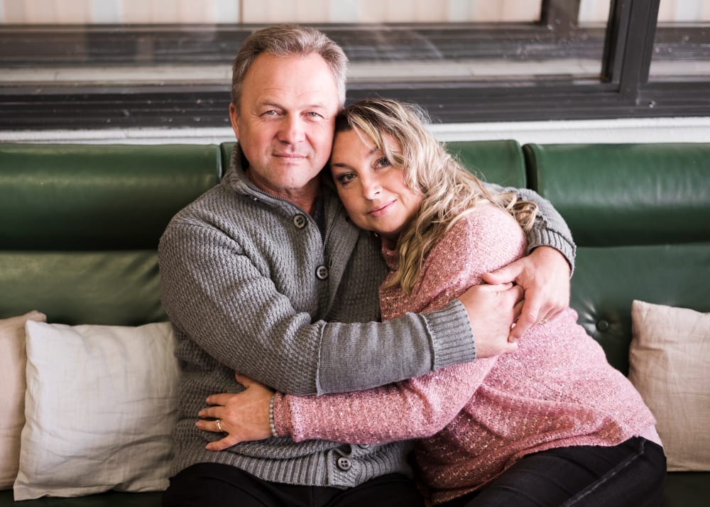 Mature married couple embracing on a couch