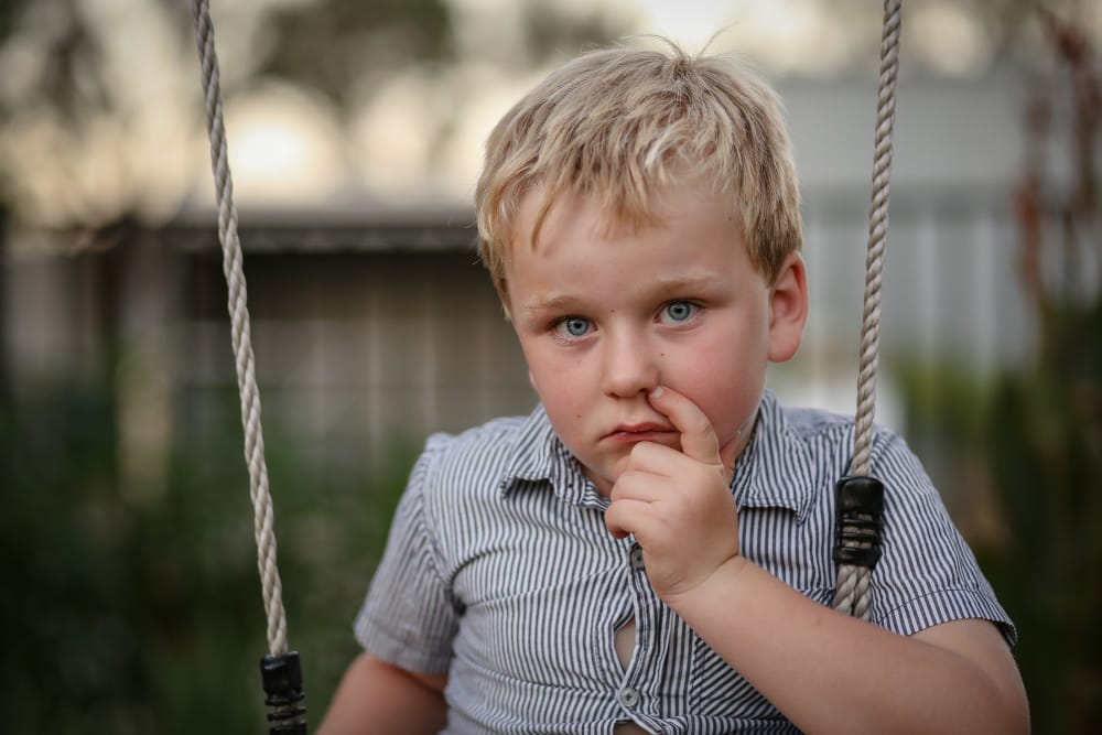 Shy little boy on a swing